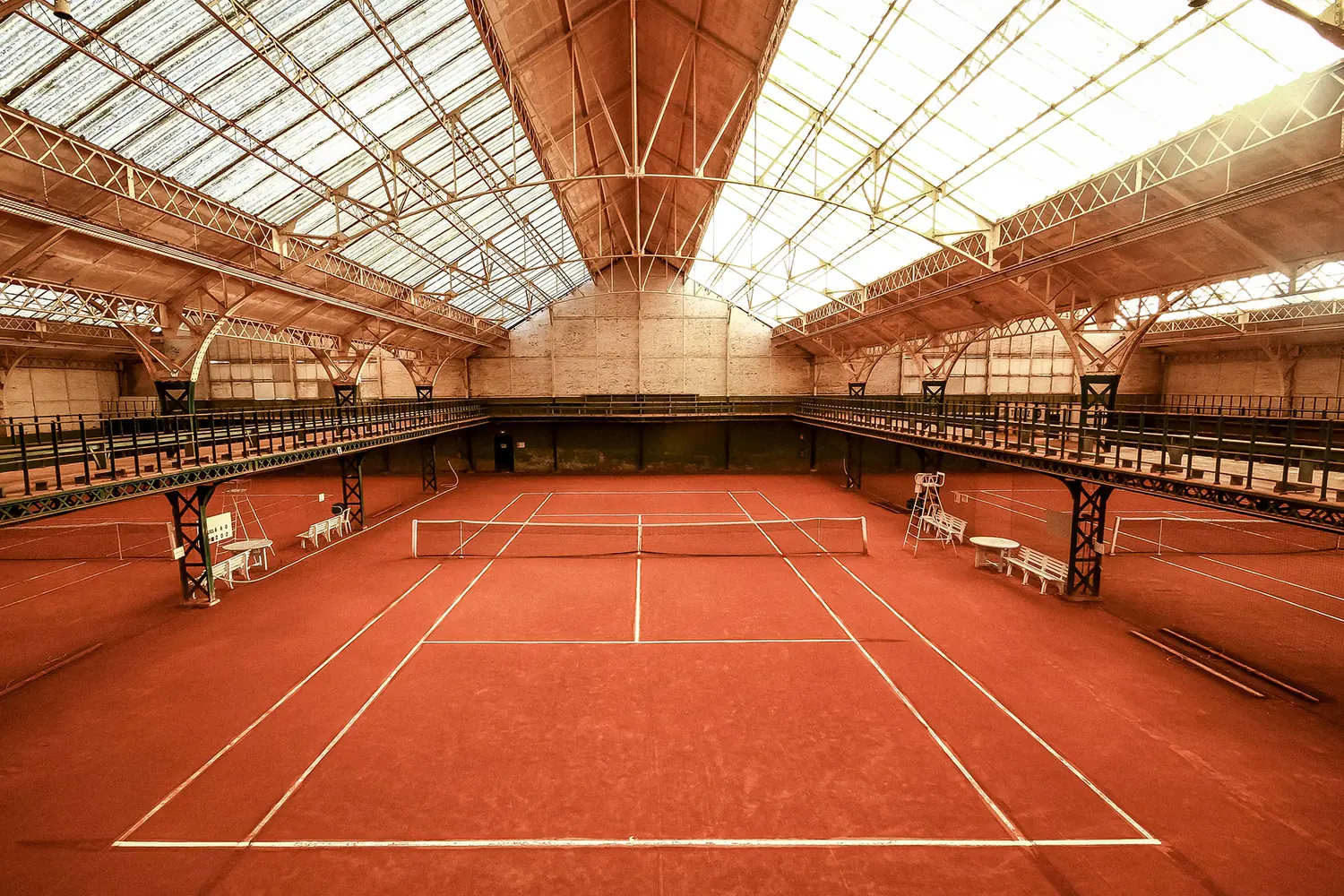 Reportage d'architecture au Tennis Club des Flandres à Croix : charpente métallique et verrière au-dessus de la terre battue